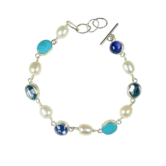 Bracelet with pearls and blue beads on a white background