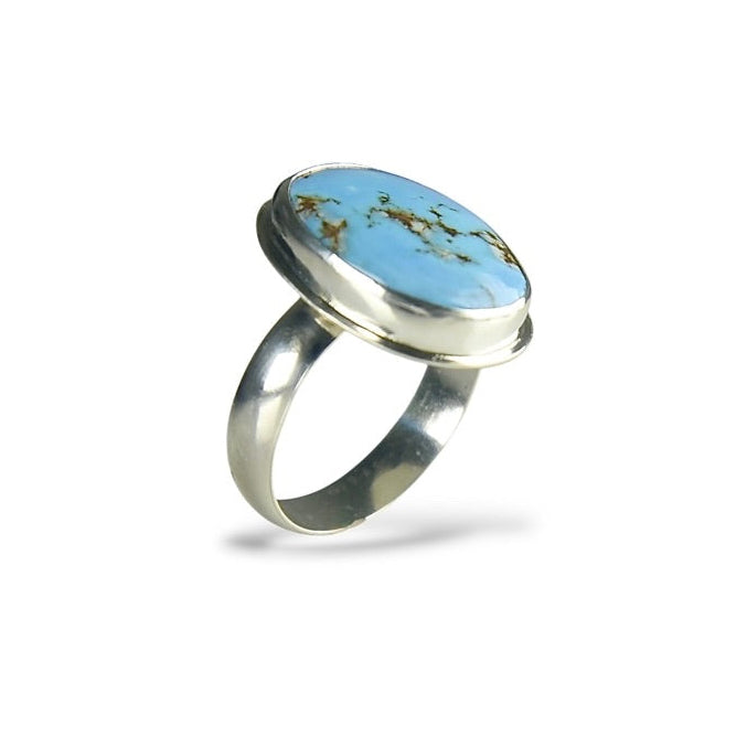 A sterling silver ring featuring a large oval turquoise cabochon with natural brown matrix veining, set against a clean white background.