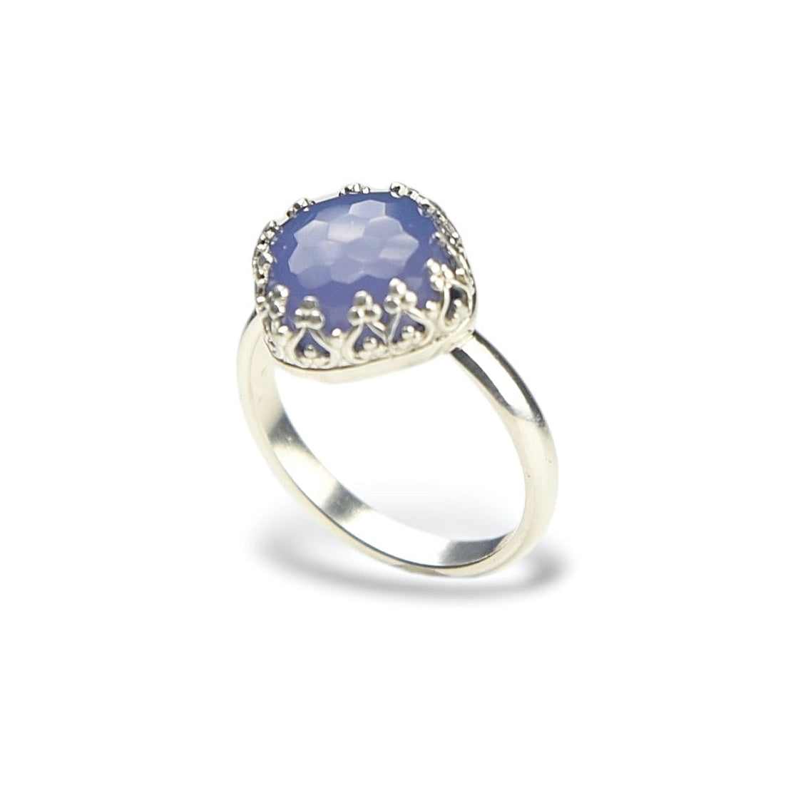 A silver ring featuring a round, faceted lavender-blue gemstone in a decorative crown-like setting, shown on a clean white background.